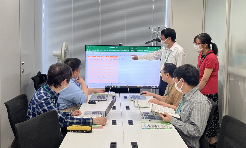 PC画面を使い、検定に合格した2回目の受講生が3回目の受講生にむけて研修を行っています。